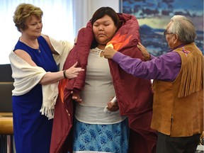Student Treasure Yellow Old Woman from Siksika is wrapped in a ceremonial blanket during the Honouring Spirit: Indigenous Student Awards hosted by the Alberta School Boards Association and the Lt. Governor of Alberta Lois E Mitchell at Government House in Edmonton, May 12, 2018.