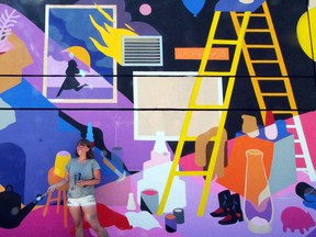 Mural artist Jill Stanton in front of her first-ever permanent outdoor mural in Edmonton at the Varscona Theatre.