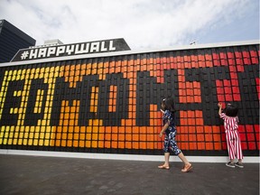 Mikhayla Bisnar, 7, and Mariesha Bisnar, 5, play with the #HappyWall art installation in Sir Winston Churchill Square, in Edmonton on Wednesday, May 16, 2018.