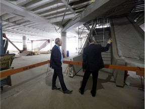 City Coun. Ben Henderson, left, and Edmonton Public Library chief financial officer Gastone Monai look at the under construction Stanley A. Milner Library prior to the start of a news conference where $4 million in joint federal-provincial funding for the revitalization of the library was announced, in Edmonton on Friday, May 18, 2018.