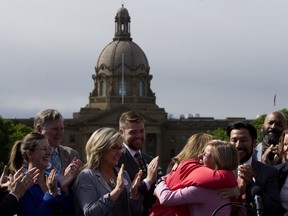 Alberta Premier Rachel Notley (right) hugs Energy Minister Margaret McCuaig-Boyd during a press conference where Notley announced that the Government of Canada, with support from the Government of Alberta, has purchased the Trans Mountain Pipeline and associated assets, during a press conference outside the Alberta Legislature in Edmonton Tuesday May 29, 2018. Photo by David Bloom