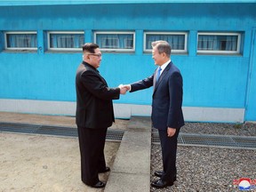 This picture taken on April 27, 2018 and released from North Korea's official Korean Central News Agency (KCNA) on April 29, 2018 shows North Korea's leader Kim Jong Un (L) shaking hands with South Korea's President Moon Jae-in (R) at the Military Demarcation Line that divides their countries ahead of their summit at the truce village of Panmunjom.