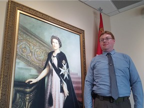 Joe Zasada, 36, poses before a portrait of the Queen in the St. John's Ambulance building at 12304 118 Ave. in Edmonton on Wednesday, May 16, 2018. Zasada is chairman of the Royal Commonwealth Society of Canada and will be waking up early to catch the royal wedding on Saturday, May 19, 2018.