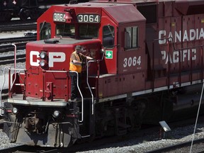 A Canadian Pacific Railway employee walks along the side of a locomotive in a marshalling yard in Calgary, Wednesday, May 16, 2012. The countdown to another Canadian railway strike is on.Canadian Pacific Railway worker are set to strike Tuesday night, potentially forcing the railroad to shut down its freight service and leaving commuters with the prospect of delays in the country's three largest cities.
