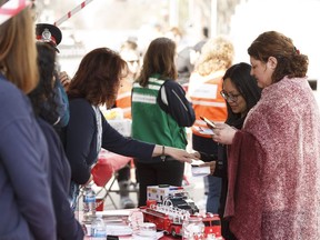 People pick up information pamphlets during an open house to kickoff Emergency Preparedness Week at the Alberta legislature grounds in Edmonton, on Thursday, May 3, 2018.