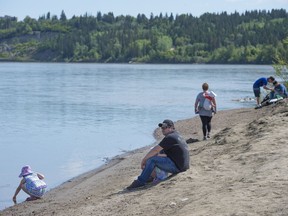 People gather on the bank of Edmonton's  North Saskatchewan River on May 27, 2018 in Edmonton.