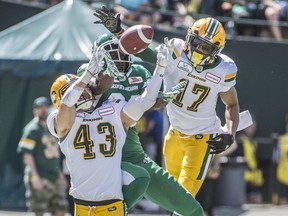 Neil King (43) and Arjen Colquhoun (17) of the Edmonton Eskimos, knock down a pass intended for Devon Bailey (83) of the Saskatchewan Roughriders at Commonwealth Stadium on May 27, 2018 in Edmonton.