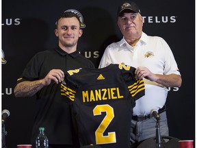 Former NFL quarterback and Heisman Trophy winner Johnny Manziel, left, holds a jersey with Hamilton Tiger-Cats head coach June Jones after announcing that he has signed a two-year contract to play in the CFL for the Tiger-Cats at a press conference in Hamilton, Ont., Saturday, May 19, 2018.