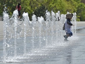 Children play in the fountains outside the Alberta Legislature in Edmonton, May 22, 2018.