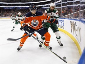 Minnesota Wild left wing Daniel Winnik (26) and Edmonton Oilers defenceman Darnell Nurse (25) battle for the puck during first period NHL action in Edmonton  on Saturday, March 10, 2018.