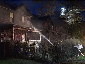 Firefighters extinguish fires at two homes on 104 Street near 107 Avenue in Edmonton, May 3, 2018.