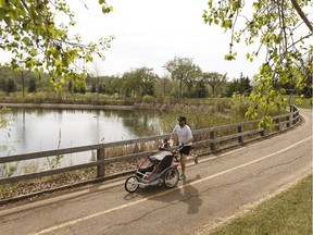 A father runs with his baby on a warm day at Rundle Park in Edmonton, on Monday, March 14, 2018.