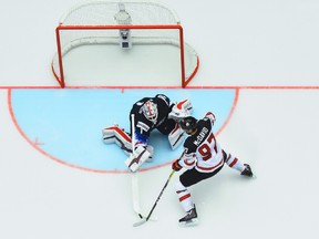 Connor McDavid is poke-checked by American goalie Keith Kincaid on the doorstep.