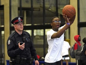 Constable Steven Den Boon watches Joseph Ndakala shoot some hoops at Clareview Community Recreation Centre on Wednesday May 16, 2018. Edmonton Police Service members from Northeast Division played basketball with junior high school students as part of an Alberta Crime Prevention Week (May 14-20) event held in Edmonton. (PHOTO BY LARRY WONG/POSTMEDIA)