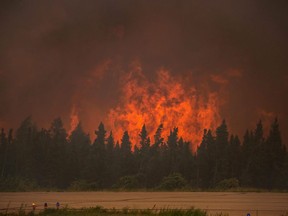 In this July 5, 2015 photo, flames rise from a wildfire near La Ronge, Saskatchewan. A new provincial program designed to improve Saskatchewan's wildfire response is set to get off the ground later this summer.