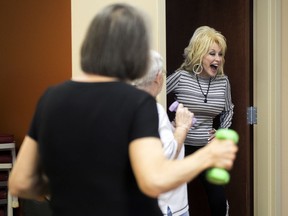 Country music superstar Dolly Parton, right, surprises an exercise class at the renamed My People Senior Activity Center in Sevierville, Tenn., Monday, May 7, 2018. Parton came for a dedication ceremony Monday to rename the facility in honor of her parents, Robert and Avie Lee Parton.