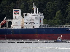 An oil tanker dwarfs an accompanying security vessel at Kinder Morgan's Trans-Mountain marine terminal, in Burnaby, B.C., on Tuesday, May 29, 2018.