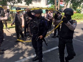 Police officers set up police line near the the site where an explosion went off at Santa Maria church in Surabaya, East Java, Indonesia, Sunday, May 13, 2018.