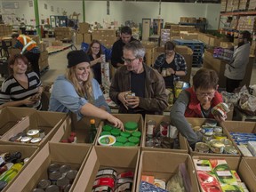 A group of 12 volunteers from Starbucks coffee shops around Edmonton take a regular volunteer shift donations into boxes.