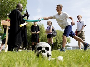 Our Lady of the Angels students battle an orc played by Paul Corrigan, assistant superintendent at Elk Island Catholic Schools, during a mythic battle which was part of a practice exam for the Grade 8 Science final, in Fort Saskatchewan on Thursday June 7, 2018. Science teacher Scott Hebert transformed the entire school field into the Land of Scientia Terra for the exam.