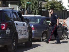 Police continue to work at the scene of car crash along 119 Avenue near 125 Street following a robbery at a nearby Canadian Tire, in Edmonton Saturday June 30, 2018.