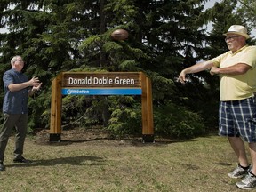 (left to right) Brothers Jim Dobie and Gord Dobie play football as they pose for a photo in the newly named Donald Dobie Green park, in Edmonton Saturday June 30, 2018. The park is named after their father, in honour of Donald Dobie's work in the community and city. Donald Dobie Green Park is located at 143 Street and 98 Avenue. Photo by David Bloom