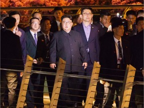 This June 11, 2018 photograph shows North Korean Leader Kim Jong Un (C) touring Singapores Marina Bay Area overlooking the city-states skyline. North Korean leader Kim Jong Un took a night-time stroll around some of Singapore's sights late June 11, 2018 ahead of his summit with US President Donald Trump.
