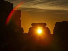 Revellers watch the sunrise as they celebrate the pagan festival of Summer Solstice at Stonehenge in Wiltshire, southern England on June 21, 2018.