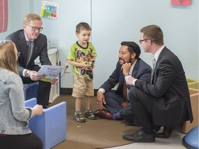 Derek Willis, five, stands with Alberta government cabinet ministers David Eggen,  left, Ricardo Miranda  and Jon Carson at the south Edmonton location of the Children's Autism Services of Edmonton on June 8, 2018. The Alberta government is providing a $1.25-million grant to support the purchase of the facility to help more than 200 families.