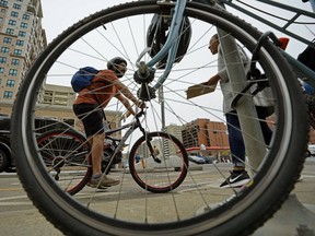 Cyclsit Elvis Pineda gets some information from bike education street team member Janada Hawthorne on 109 Street near 100 Avenue in downtown Edmonton. The City of Edmonton  bike education street team and Edmonton Police Service spoke with motorists, cyclists and pedestrians along the downtown bike network on Tuesday June 26, 2018, reminding all road users of the rules when travelling along the protected bike lanes.