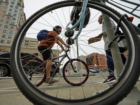 Cyclsit Elvis Pineda gets some information from bike education street team member Janada Hawthorne on 109 Street near 100 Avenue in downtown Edmonton. The City of Edmonton bike education street team and Edmonton Police Service spoke with motorists, cyclists and pedestrians along the downtown bike network on Tuesday June 26, 2018, reminding all road users of the rules when travelling along the protected bike lanes.