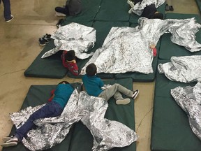 In this photo provided by U.S. Customs and Border Protection, people who've been taken into custody related to cases of illegal entry into the United States, rest in one of the cages at a facility in McAllen, Texas, Sunday, June 17, 2018.