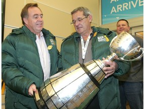 Co-chairs of the Edmonton Grey Cup 2010 Edmonton Eskimos' Chairman Doug Goss, left, and Eskimos' President and CEO Rick LeLacheur hold the Grey Cup as it arrives at the Edmonton International Airport, Nov. 23, 2010.