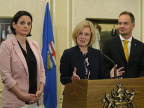 A swearing-in ceremony was held at Government House in Edmonton on Monday June 18, 2018 after Alberta Premier Rachel Notley (middle) announced a cabinet shuffle. Calgary-Currie MLA Brian Malkinson (right) was named Service Alberta Minister, replacing Calgary-Varsity MLA Stephanie McLean. McLean's status of women portfolio is being absorbed by Children's Services Minister Danielle Larivee (left). Associate Health Minister Brandy Payne was also moved out of cabinet and her position was being eliminated. (PHOTO BY LARRY WONG/POSTMEDIA)