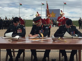 Lt. Col. Mark Lubiniecki, left, Brigadier General Trevor Cadieu and Lt.-Col. Eric Angell sign documents to finalize the change of command proceedings on Wednesday, June 27, 2018.