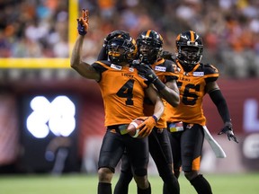 From left, B.C. Lions' Garry Peters celebrates his interception against the Montreal Alouettes Saturday with teammates Anthony Thompson and Solomon Elimimian.