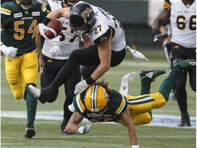 Hamilton Tiger-Cats Mercer Timmis (27) is taken out be Edmonton Eskimos Aaron Grymes (36) during first half CFL action in Edmonton on Friday June 22, 2018.