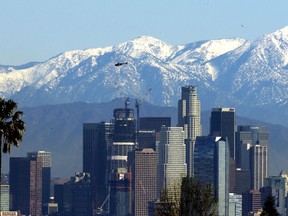 File - In this Jan. 12, 2016 file photo, the snow-capped San Gabriel Mountains stand as a backdrop to the downtown Los Angeles skyline. An initiative that seeks to split California into three states is projected to qualify for the state's November 2018 ballot. The latest proposal for splitting up the Golden State would create the states of Northern California, Southern California and a narrow central coast strip retaining the name California. Even if voters approve the initiative an actual split would still require the approval of the state Legislature and Congress.