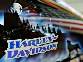An American flag is reflected in the gas tank of a 2006 Roadking Custom in the showroom of Harley-Davidson of New York.