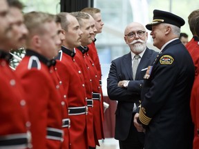 Fire Chief Ken Block, right, and city Coun. Scott McKeen review Edmonton Fire Rescue Services Class 148 fire recruits during a graduation ceremony at City Hall in Edmonton on Friday, June 1, 2018.