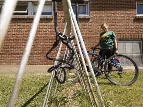 Leanne Robinson poses for a photo at the bike racks where her son had two bikes stolen at Our Lady of Mount Carmel School in Edmonton, on Monday, June 4, 2018. Robinson says the racks are out of view of the school and in a poorly protected area.