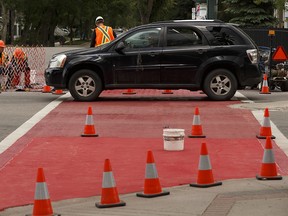 Workers with Canadian Road Builders paint the sidewalk at 124 street and 109A Avenue to improve visibility in Edmonton, on Thursday, June 14, 2018. A second sidewalk at 124 Street and 110 Avenue was also painted. Photo by Ian Kucerak/Postmedia