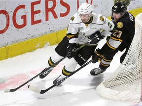 Evan Bouchard lugs the puck out from behind his own net being chased by Sarnia's Curtis Egert in the first period of their Friday December 15, 2017 game at Budweiser Gardens.  Mike Hensen/The London Free Press/Postmedia Network