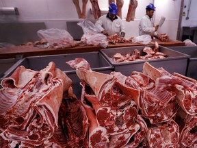 FILE - In this file photo taken on Monday, July 18, 2016, butchers prepare cuts of meat at Smithfield Market, in London. A shortage of carbon dioxide in Europe is hitting food processing companies who rely on the gas to stun animals before slaughter, as it is announced Tuesday June 26, 2018, that some meat processing plants will run out of CO2 within days.