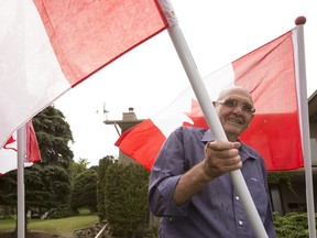 Ken Haverland shows one of many Canadian flags he gives to people who donate to charity at his home in Edmonton, Alta., on Monday June 30, 2014. File photo.