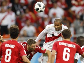 Peru's Alberto Rodriguez, centre, and Denmark's Simon Kjaer, second left, jump for a ball during the group C match between Peru and Denmark at the 2018 soccer World Cup in the Mordovia Arena in Saransk, Russia, Saturday, June 16, 2018.