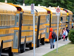 School buses line up outside a northeast Calgary school waiting to take students home in a 2014 photo.