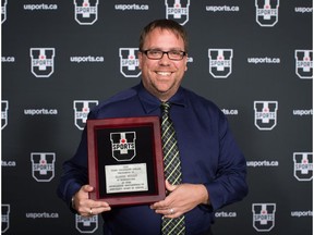 Postmedia sports reporter Jason Hills, of the Edmonton Sun and Edmonton Journal, poses with the Fred Sgambati Award after being honoured for his coverage of university sports, at the U Sports Athletes of the Year awards in Vancouver, on Monday June 4, 2018.