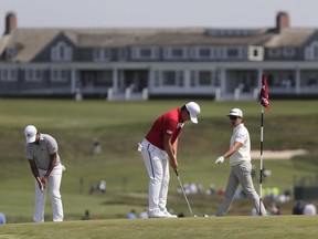 From left, Si Woo Kim, Sungjae Im and Sung Joon Park, all of South Korea, practice putting on the seventh green during a practice round for the U.S. Open Golf Championship, Monday, June 11, 2018, in Southampton, N.Y.