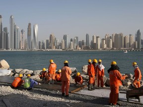 FILE - In this Sept. 22, 2015 file photo, laborers work at a construction site at the Palm Jumeirah, in Dubai, United Arab Emirates. A new report released Tuesday, June 12, 2018, by the Washington-based Center for Advanced Defense Studies, relying on leaked property data from the city-state, described Dubai's real-estate market as a haven for money launderers, terror financiers and drug traffickers sanctioned by the U.S. in recent years. Officials in Dubai said they could not comment on the report.